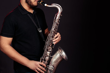 Fototapeta na wymiar young guy plays the saxophone. Close up