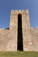 Fragment of a high fortified restored wall with an arch in the p