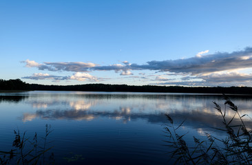 Sunset on the lake. Beautiful sunset nature. Evening landscape. Clouds over the lake.