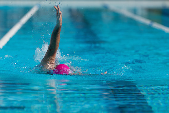 Male swimmer in an outdoor swimming pool, swim backstroke