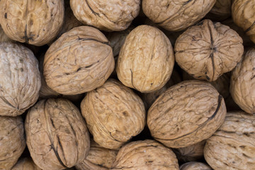 Whole walnuts on the market counter, background
