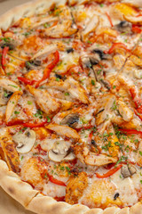 Hot chicken pizza with mushrooms and bell pepper with a thick crust in a delivery box