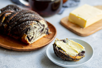  Poppy seed roll with butter and tea. Baking with poppy seeds. The work of the baker. Baking rolls with poppy seeds and pies in the kitchen. Bakery, cook together.