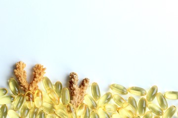 Fototapeta premium Omega 3 capsules lying on white background like the seabed with corals. Fish oil in pills. Health support and treatment. Biologically active additives.