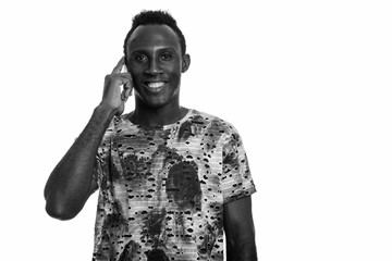 Young happy black African man smiling while talking on mobile phone