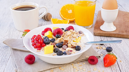 muesli, milk and fruit with coffee cup and orange juice