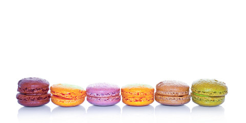 Row of pastel colored french macarons, on white background
