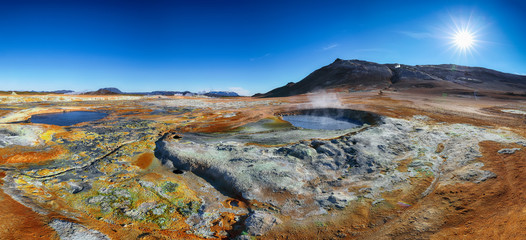 Boiling mudpots in the geothermal area Hverir and cracked ground around.