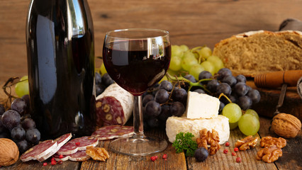 red wine with grapes, cheese, bread and salami