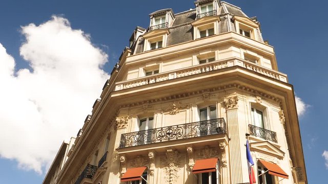 Luxury apartment building in the uber central Paris on Champs Elysees with French flag hanged on the facade