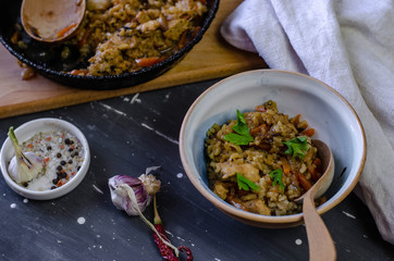 A pan and plate of homemade pilaf with garlic and  chilli pepper