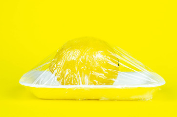 Fresh food in plastic package recycling and environment eco problem concept. Lemon wrapped in...