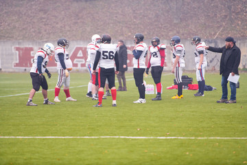 american football players discussing strategy with coach