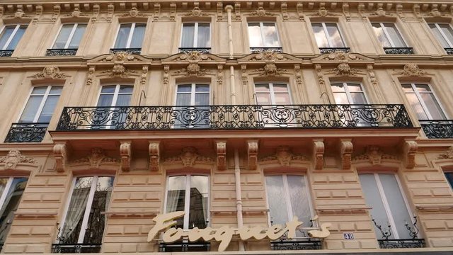 Tilt-down to Fouquet's facade insignia the historic high-end brasserie restaurant in Paris on 99 Avenue des Champs-&Eacute;lysees 
