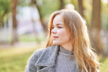 red-haired young woman in a golden autumn park