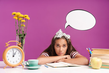 Attractive young girl sitting at the desk