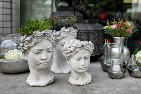 Gypsum Flower Pot In The Shape Of Antic Head Of Goddess With Growning Out Green Flowers. Stylish Home Decor