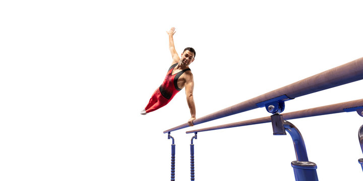 Male athlete doing a complicated exciting trick on parallel bars on white background. Isolated Man perform stunt in bright sports clothes