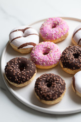 Colorful donuts on marble background with copy space