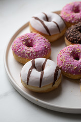 Colorful donuts on marble background with copy space