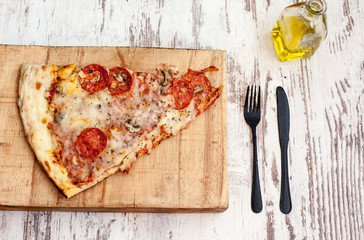 pizza with tomatoes and olives on wooden board