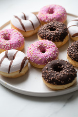 Colorful donuts on marble background with copy space