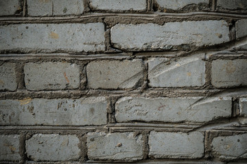 Texture of an old paint covered brick wall. Background image of an abandoned brick wall with painted over paint