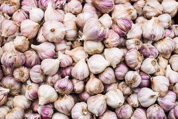 A lot of garlic in a box on the market. Autumn harvest sale. Top view, copy space