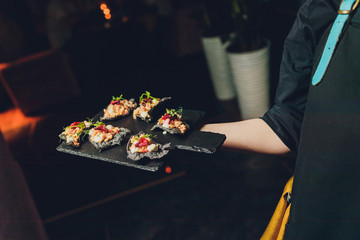 A waiter with a tray of snacks at a banquet or reception. Catering buffet at party.