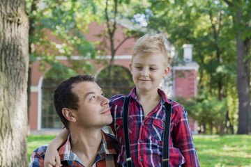 Naklejka premium Beautiful dad and son are walking in the park.