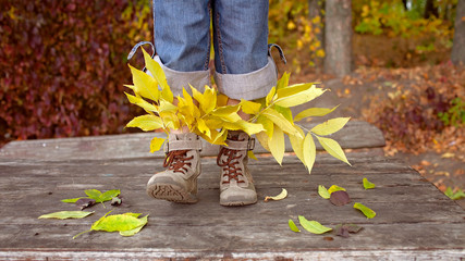 Cute girl in hipster style shoes with bright leaves inside