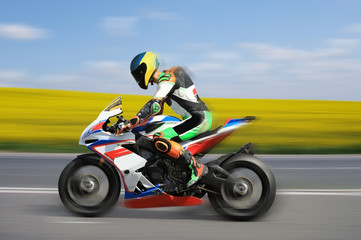 Fototapeta premium Racing bike rider racing at high speed on a colorful background