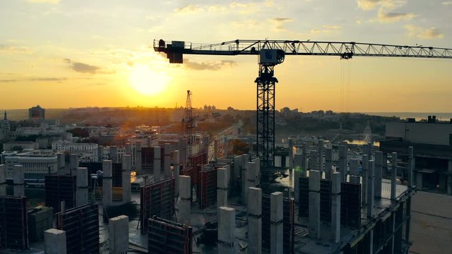Building lot with machinery at the sunset cityscape