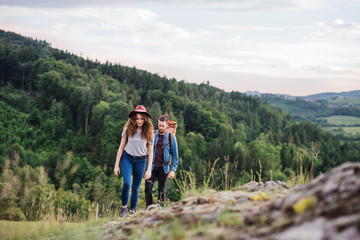 Fototapeta premium Young tourist couple travellers with backpacks hiking in nature.