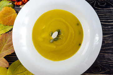 pumpkin soup in white plate wooden background autumn theme