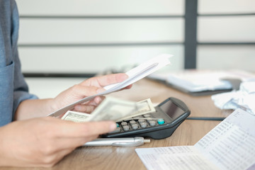 Fototapeta premium man calculate domestic bills. Businessman with calculator checking balance & costs. Startup counting finance for paying taxes