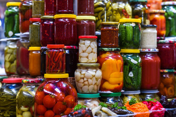 assorted homemade preservation in jars of vegetables and preserves
