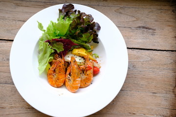 mango salad with shrimp on wood table