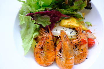 mango salad with shrimp on wood table