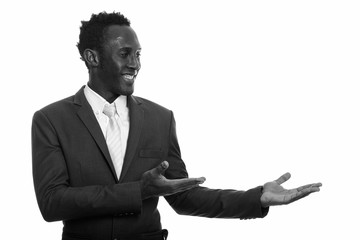 Young happy black African businessman smiling and showing something