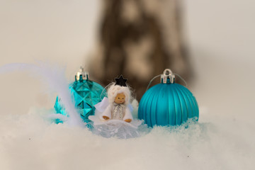 angel and christmas balls in snow with bokeh background; christmas card with copy space
