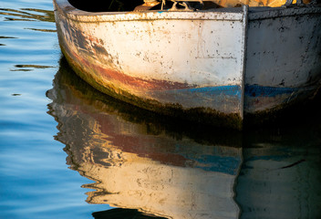 Fototapeta na wymiar Colofrul metal boat and its reflection in water