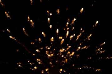 Abstract Bokeh Firework Background. Abstract blurred golden yellow fireworks light up the dark black sky with bokeh background. Concept for diwali, new year, party, 4th july, anniversary, celebration.
