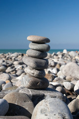 Stones balance, pebbles stack over blue sea .