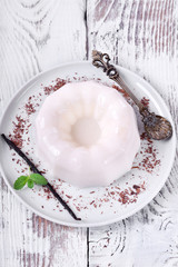 White vanilla milk jelly on ceramic plate on white wooden table