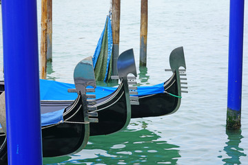 A gondola on the aqua green water of a Venice canal in winter