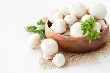 Fresh mushrooms champignon in brown bowl on white background. 