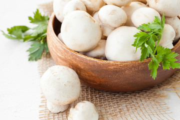 Fresh mushrooms champignon in brown bowl on white background. 