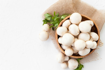 Fresh mushrooms champignon in brown bowl on white background. 