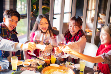 Happy friends having fun in hot pot restaurant